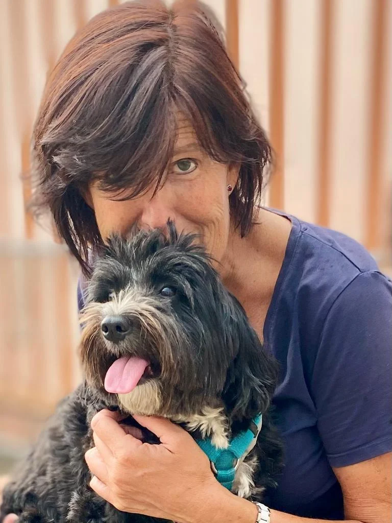 Danni Hartmann mit einem schwarzen, zotteligen Hund im Arm